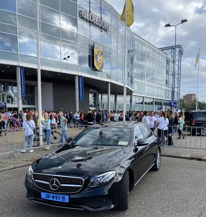 Zwarte Mercedes-Benz taxi bij het GelreDome in Arnhem tijdens een evenement